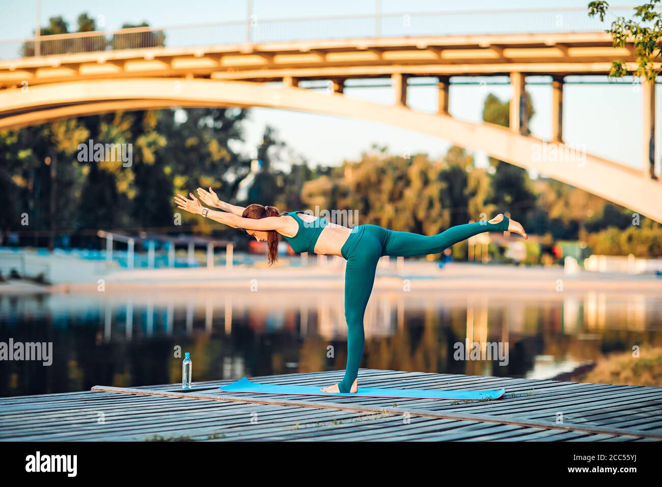 Sport donna fare yoga su piattaforma di legno Foto Stock