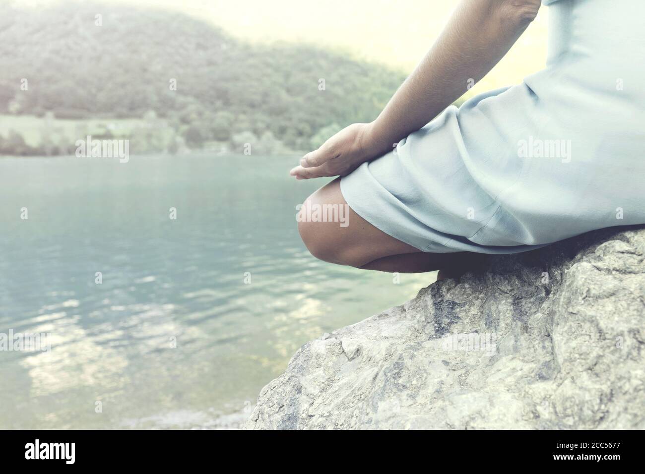 donna che prende un respiro di fronte ad un lago incantato Foto Stock