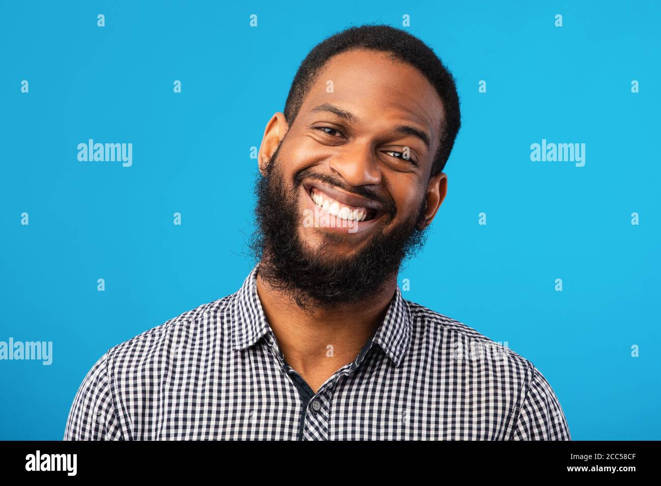 Sorridente ritratto di uomo afro su sfondo blu Foto Stock