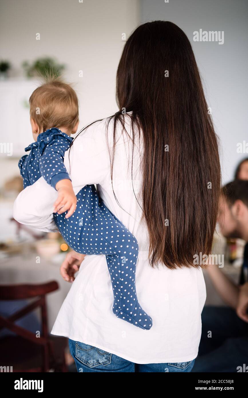 donna che tiene il bambino in braccio, vista posteriore Foto Stock