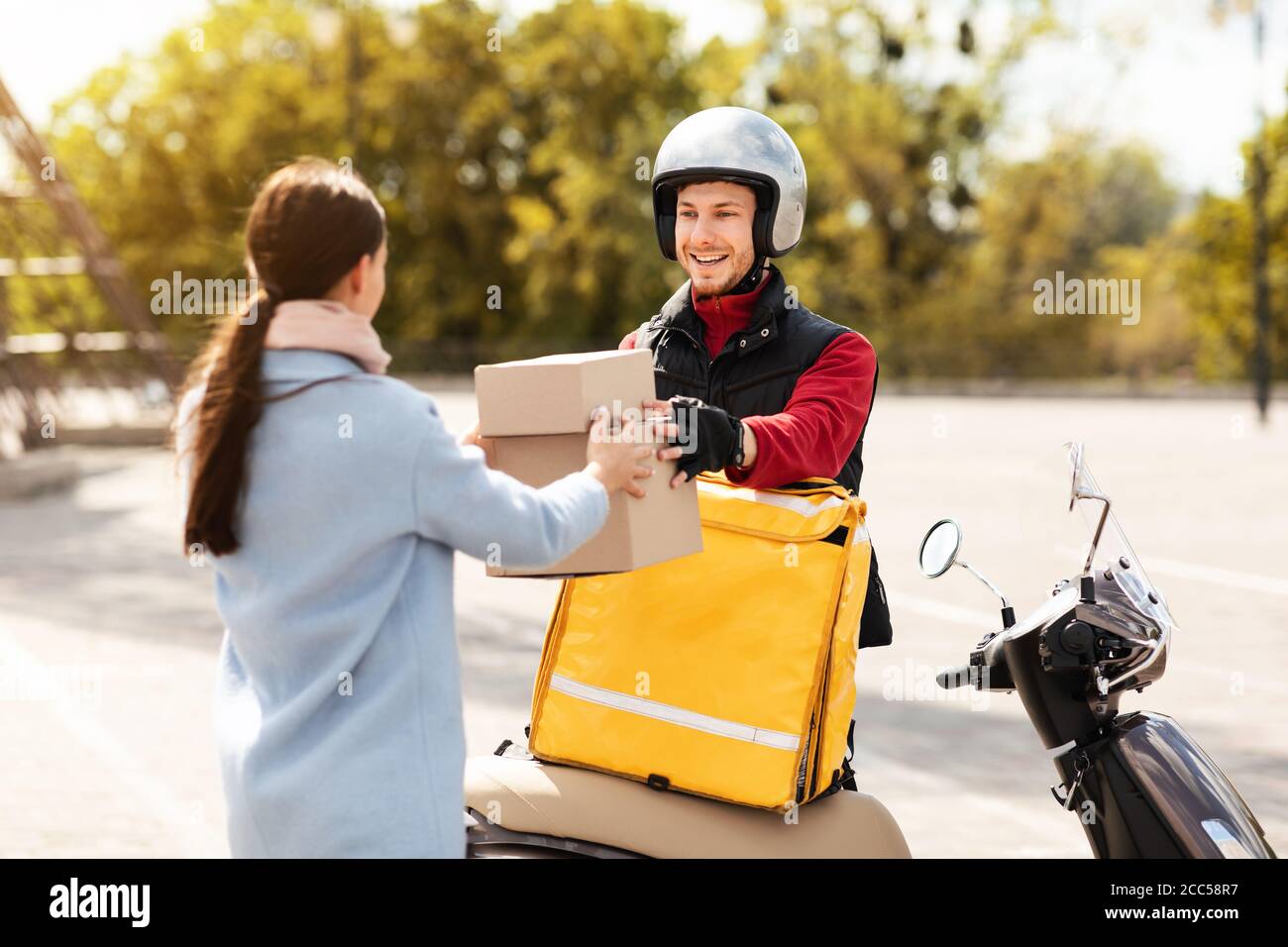 Corriere Guy consegna pacchi al cliente all'aperto Foto Stock