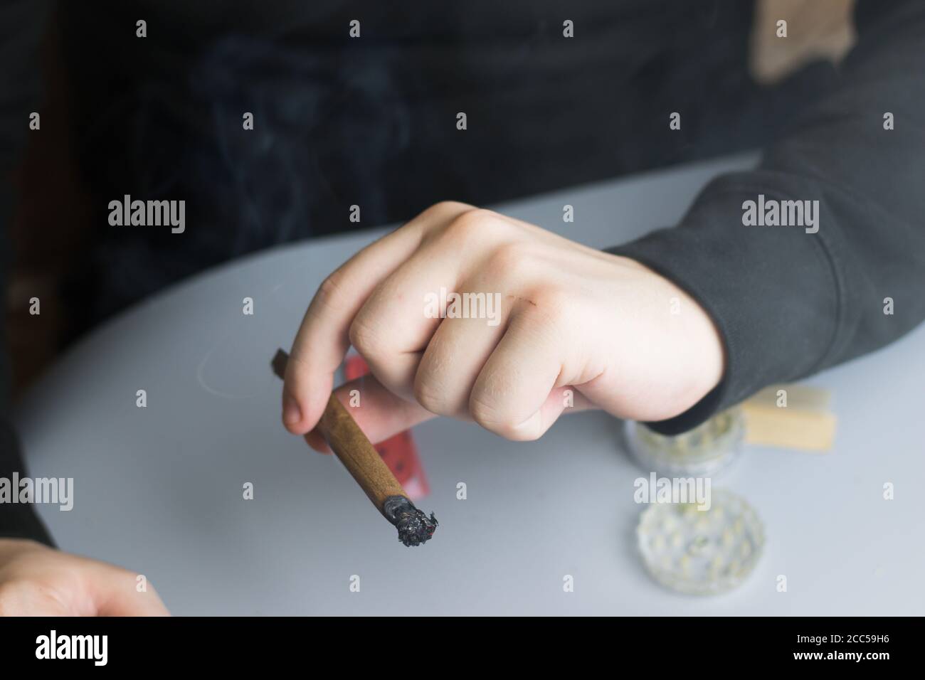 Uomo che passa la cannabis smussata ad un amico in festa con ricreativo droghe Foto Stock