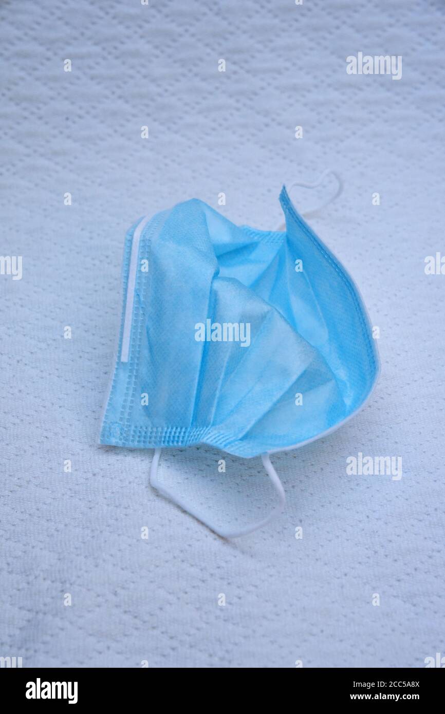 Maschera chirurgica monouso su tessuto bianco sfondo Foto Stock