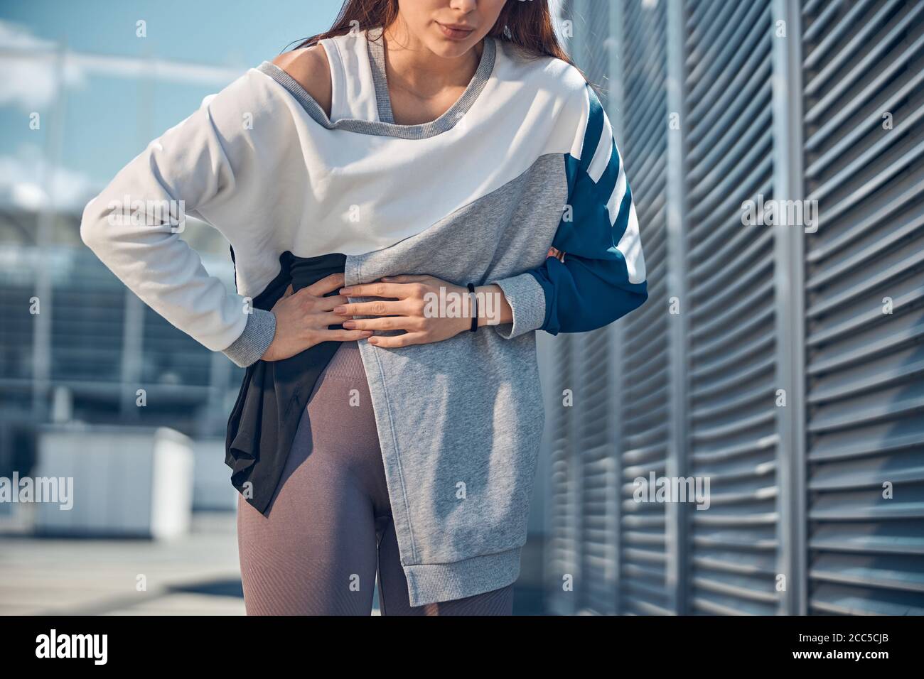 Donna caucasica con stomachache in piedi all'aperto Foto Stock