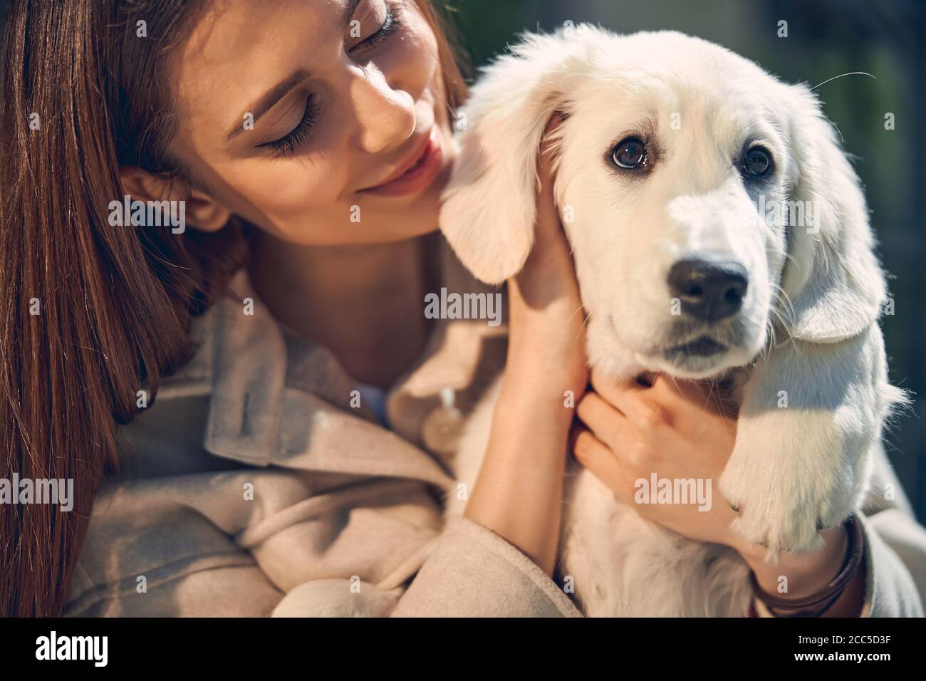 Sorridente compiaciuta donna e il suo adorabile cane Foto Stock