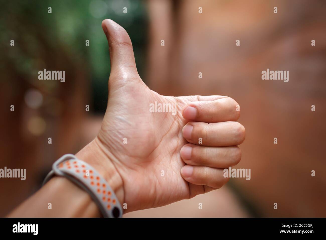 Primo piano della posa della mano dell'uomo con il pollice verso l'alto Foto Stock