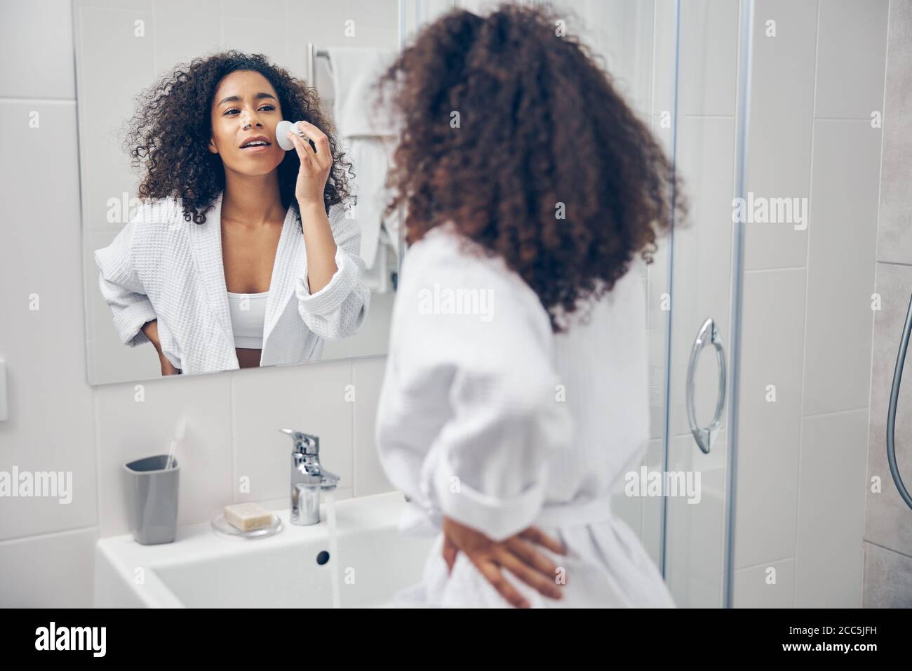 Donna riccia-testa concentrata sbarazzarsi di blackheads Foto Stock