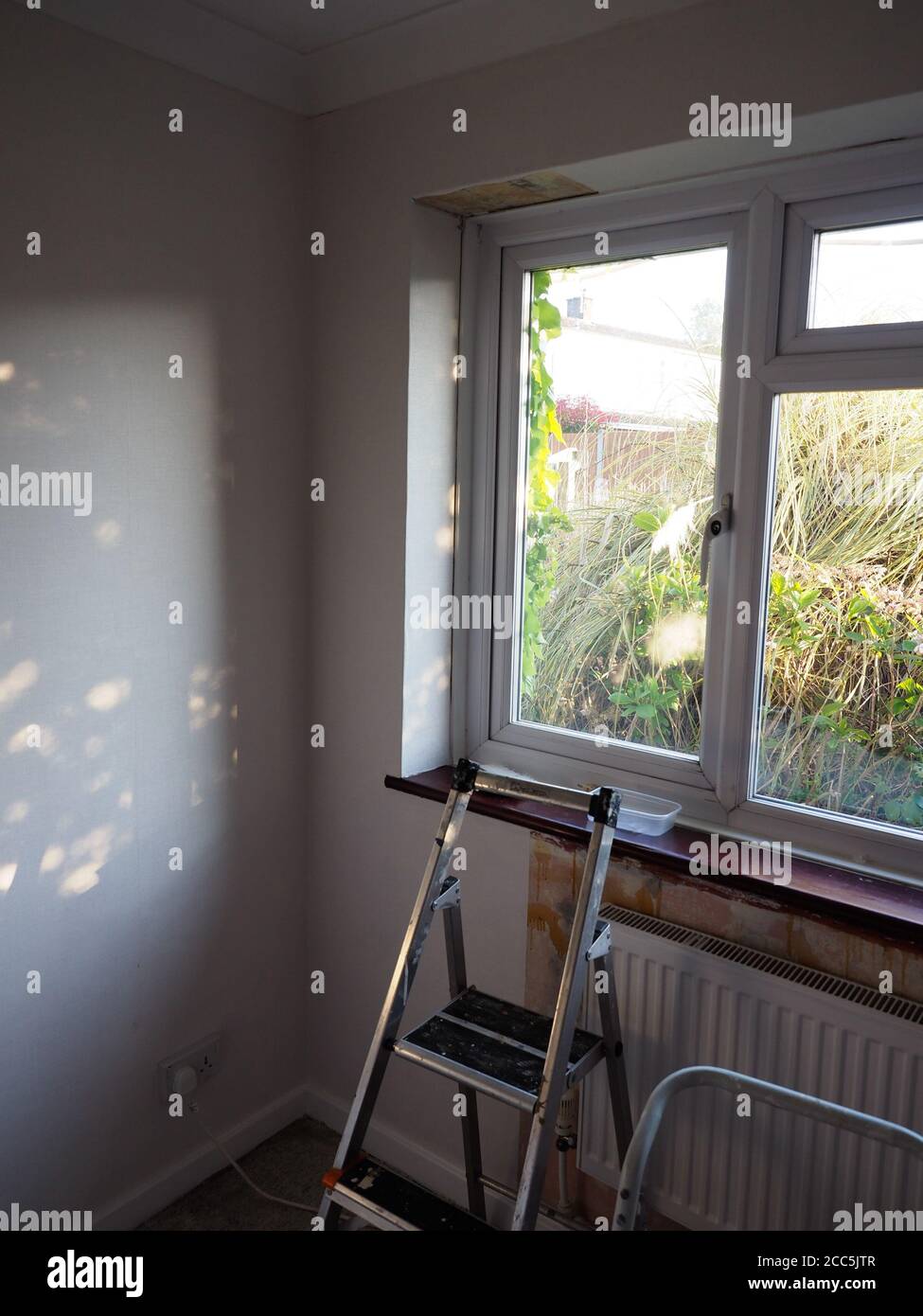 una camera è decorata mostrando pareti in parte papate e un scala a cavalletto Foto Stock