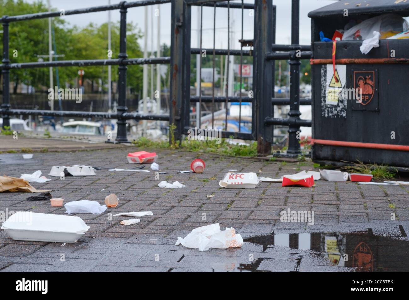 Spazzatura e lettiera che circondano un cestino di rifiuti a Preston Docks nel Lancashire. Foto Stock