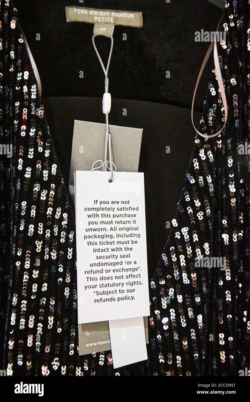 Un abito da Fenn Wright Manson con un'etichetta che specifica che l'articolo deve essere non indossato per la qualità per un rimborso. I rivenditori di moda stanno combattendo sempre più alti tassi di rendimento. Foto Stock
