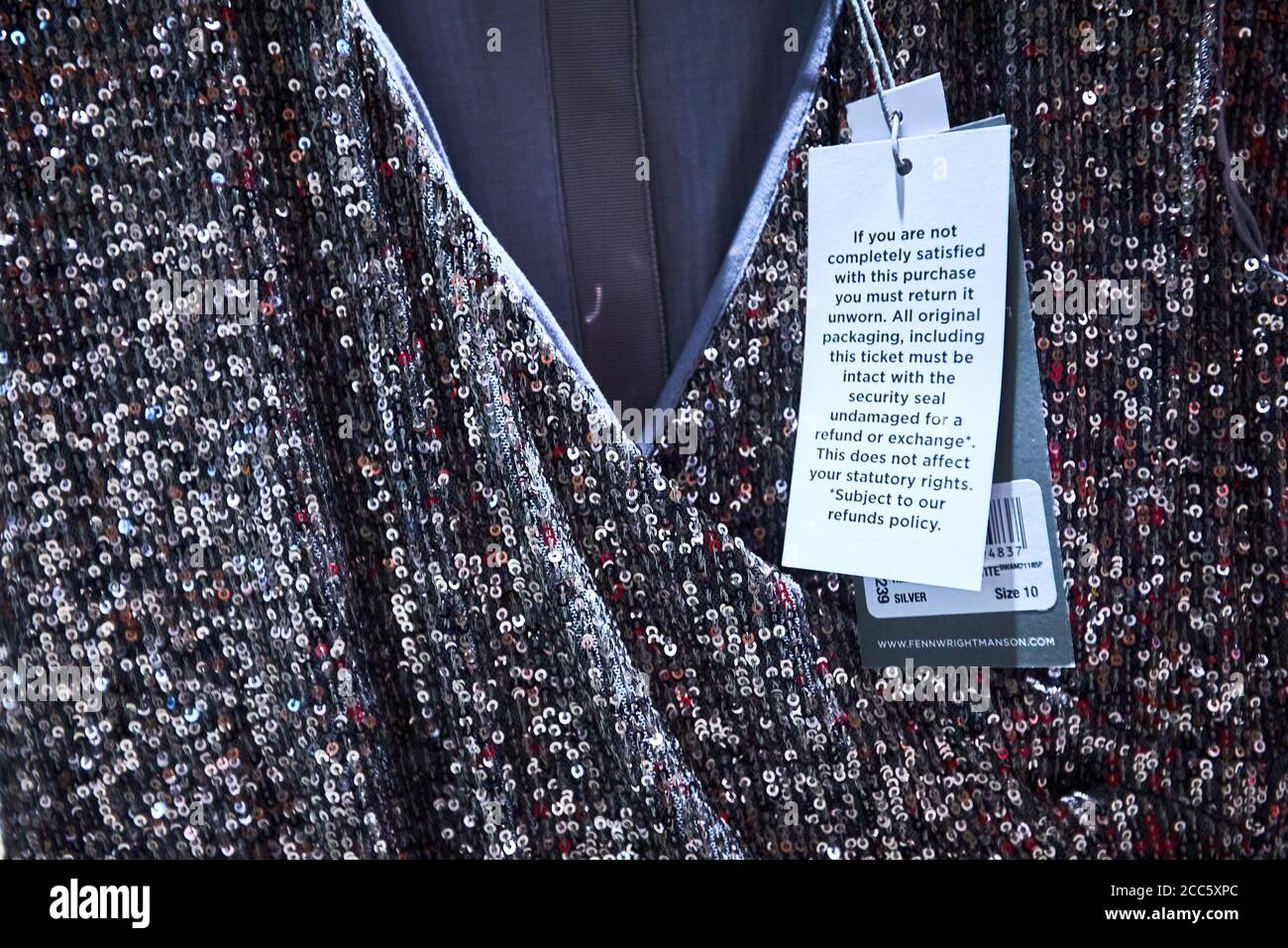 Un abito da Fenn Wright Manson con un'etichetta che specifica che l'articolo deve essere non indossato per la qualità per un rimborso. I rivenditori di moda stanno combattendo sempre più alti tassi di rendimento. Foto Stock