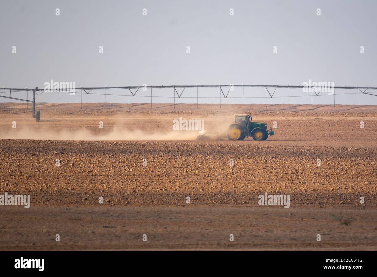 Trattore che arava un campo nel deserto di Negev, Israele fotografò a Kibbutz Magen Foto Stock
