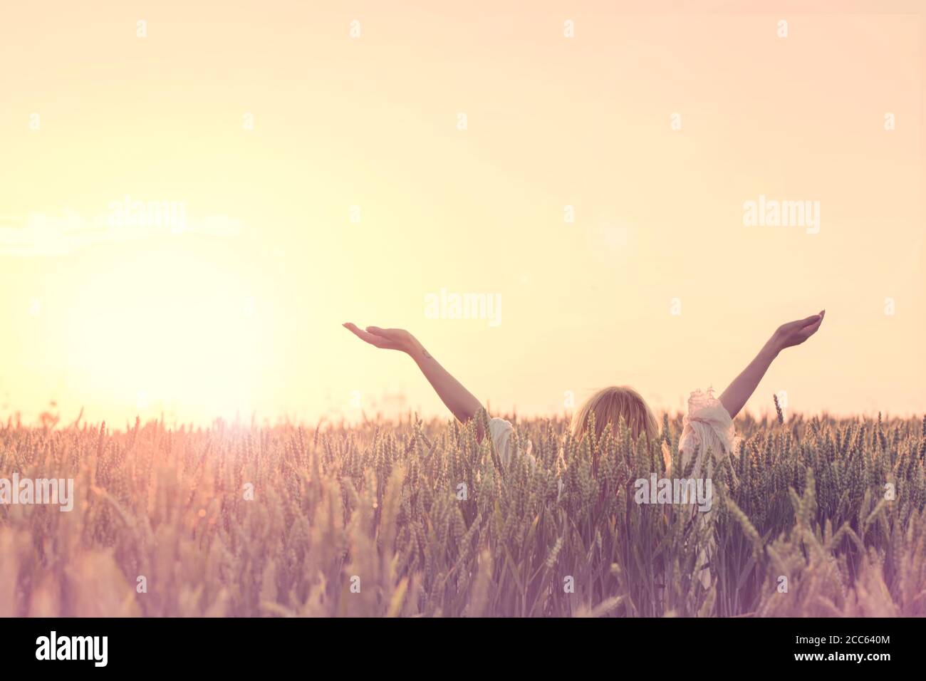 buon sole del mattino , donna con braccia sollevate abbraccia la nascita di un nuovo giorno Foto Stock