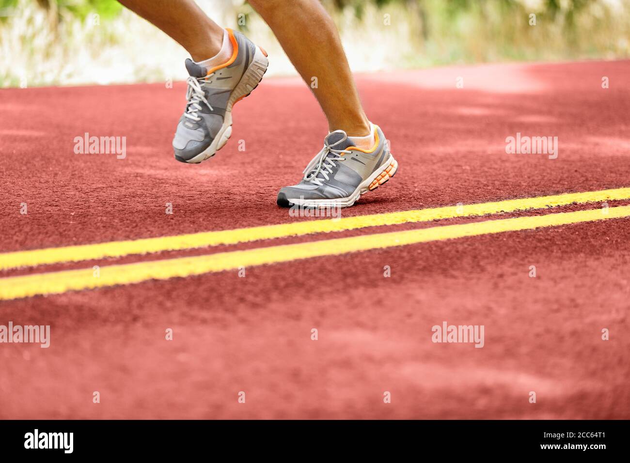Uomo che corre da linee doppie gialle su strada Foto Stock