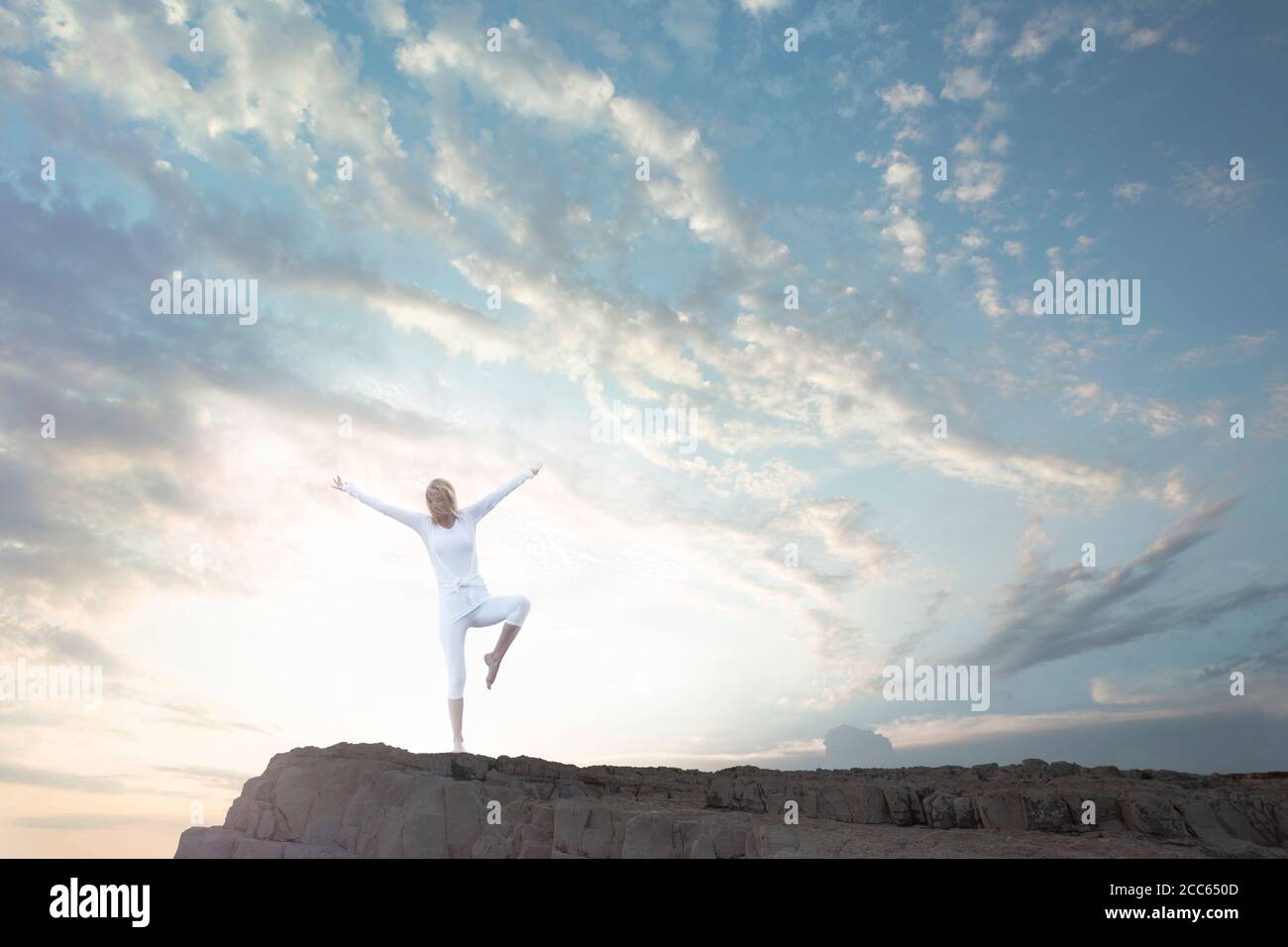 donna che fa esercizi di yoga immersi nella natura in alto scogliera Foto Stock