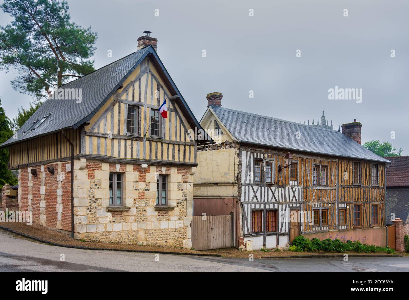Vecchie case a graticcio, tipico stile della Normandia, bandiera francese. Le Bec Hellouin, Francia Foto Stock