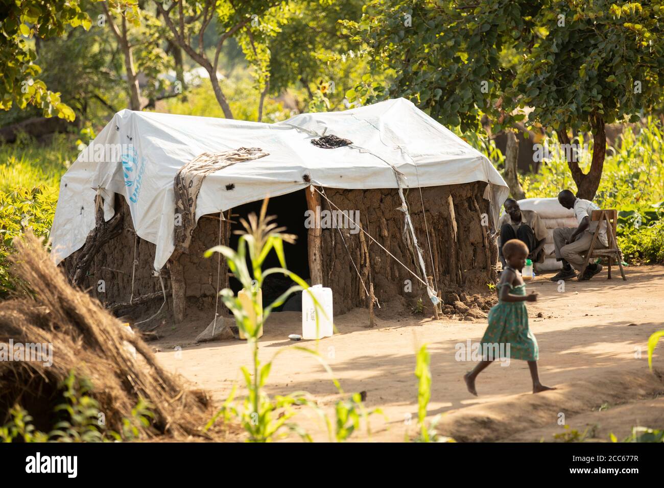 I rifugiati del Sud Sudan vivono in case di fango e paglia d'erba di fortuna coperte di teloni di telone nell'insediamento dei rifugiati di Palabek, nel nord dell'Uganda, Africa orientale. Foto Stock