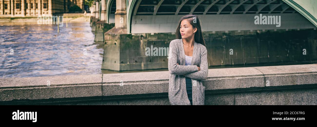 Città stile di vita giovane donna asiatica prendere una pausa sulla strada della città di Londra rilassante vicino al Tamigi dal Big ben, Regno Unito, Europa. Banner panoramico Foto Stock