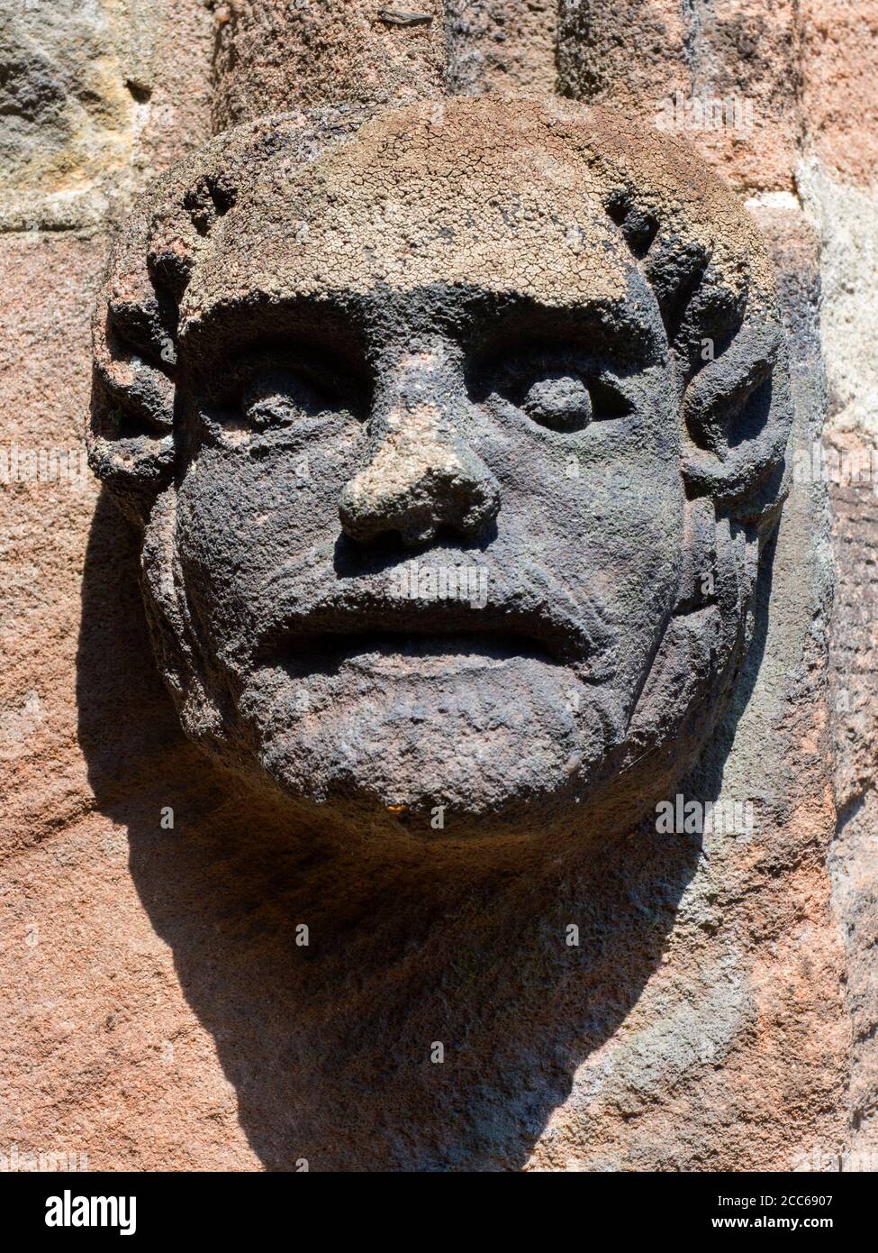 Dettaglio della scultura del viso all'ingresso della Chiesa di San Joseph e Saint James a Follifoot Harrogate North Yorkshire Inghilterra Foto Stock