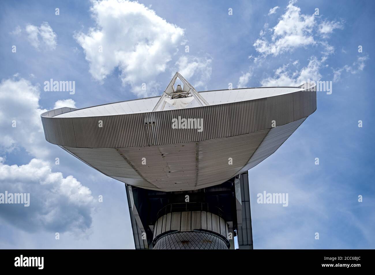 parte di un'antenna parabolica di comunicazione satellitare di grandi dimensioni nella parte anteriore di un cielo blu nuvoloso Foto Stock