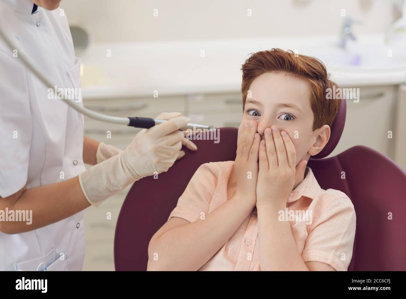 Il bambino ha paura di avere i suoi denti trattati. Cura e trattamento dentale. Odontoiatria per bambini. Ufficio del dentista. Foto Stock