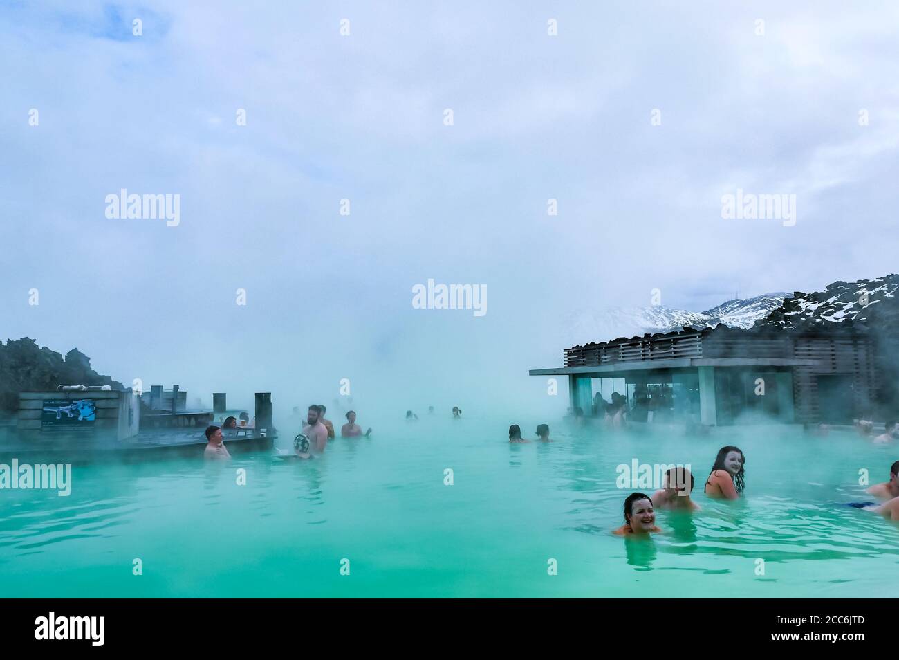 Le persone che nuotano in acque termali geotermiche calde e steamy presso il resort Blue Lagoon in Inverno, Islanda Foto Stock