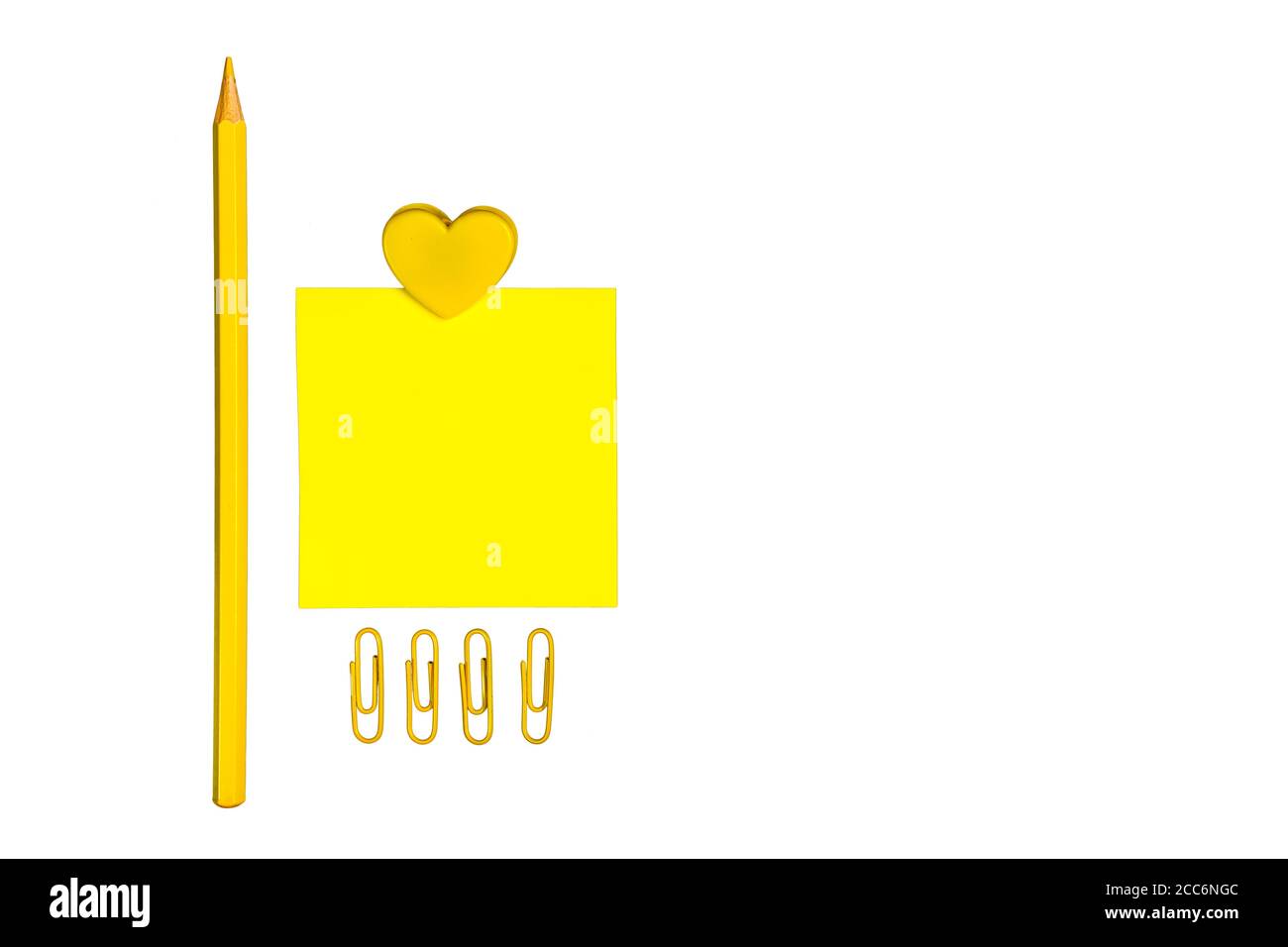 Forniture scolastiche gialle isolate su sfondo bianco. Nota adesiva, matita colorata, graffette e clip a forma di cuore. Design moderno e minimalista. Schoo Foto Stock