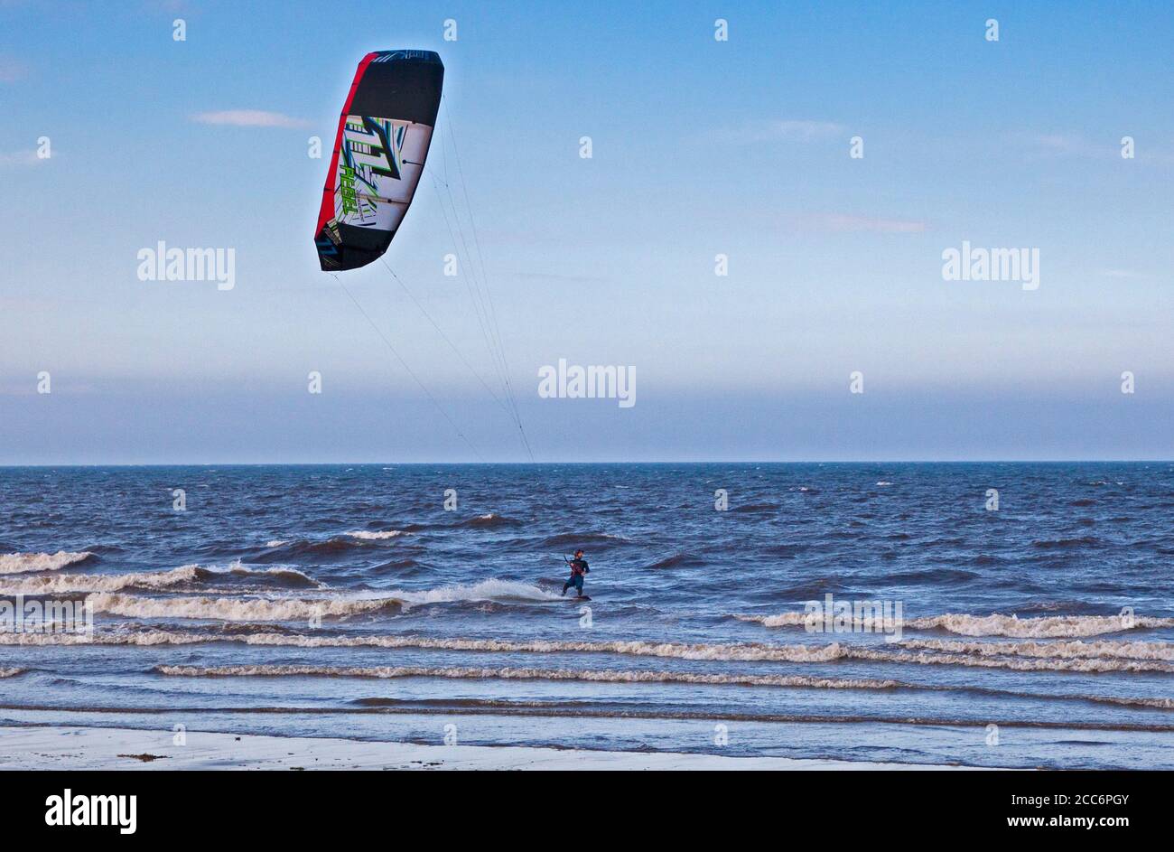 Portobello, Edimburgo, Scozia, Regno Unito. 19 agosto 2020. Il ventoso pomeriggio ha fatto esplodere la foschia che persisteva al mattino con gli incantesimi sparsi di sole più tardi. Vento 22 km/h con potenziali raffiche di 42 km/h assistendo questo Kite Surfer. Foto Stock