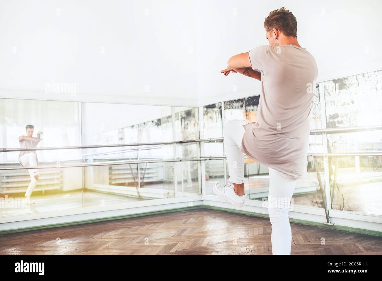 Il ballerino d'arte moderna, adolescente, pratica movimenti di danza di fronte lo specchio in una sala da ballo Foto Stock