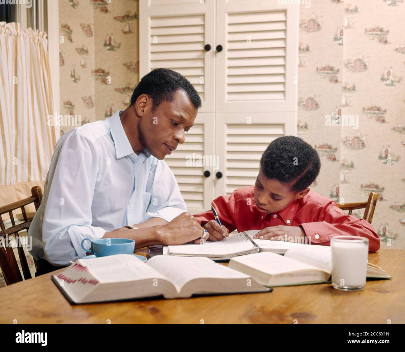 1970 PADRE AFROAMERICANO CHE AIUTA IL FIGLIO CON I COMPITI A TAVOLA DELLA CUCINA UOMO RAGAZZO CHE STUDIA IL LAVORO SCOLASTICO - KJ5659 PHT001 HARS OCCUPATO FUTURO NOSTALGIA COMPITI VECCHI MODA GIOVANI COMUNICAZIONE TEAMWORK INFORMAZIONI SNACK FIGLI LIFESTYLE SODDISFAZIONE PARENTING RELAZIONE GROWNUP HOME VITA COPIA SPAZIO PERSONE BAMBINI AMICIZIA PERSONE DI MEZZA LUNGHEZZA ADULTI MASCHI AMERICANI PADRI ALIMENTI SNACK ALIMENTI PATERNAL SINGOLO GENITORE E BAMBINO OBIETTIVI SPUNTINI SINGOLO GENITORI GENITORI GENITORI E FIGLI PATERNITÀ MINORANZA NUTRONO CIBO SNACK AFROAMERICANI AFROAMERICANO E PAPÀ CONOSCENZA ETHNIC DIVERSITÀ Foto Stock