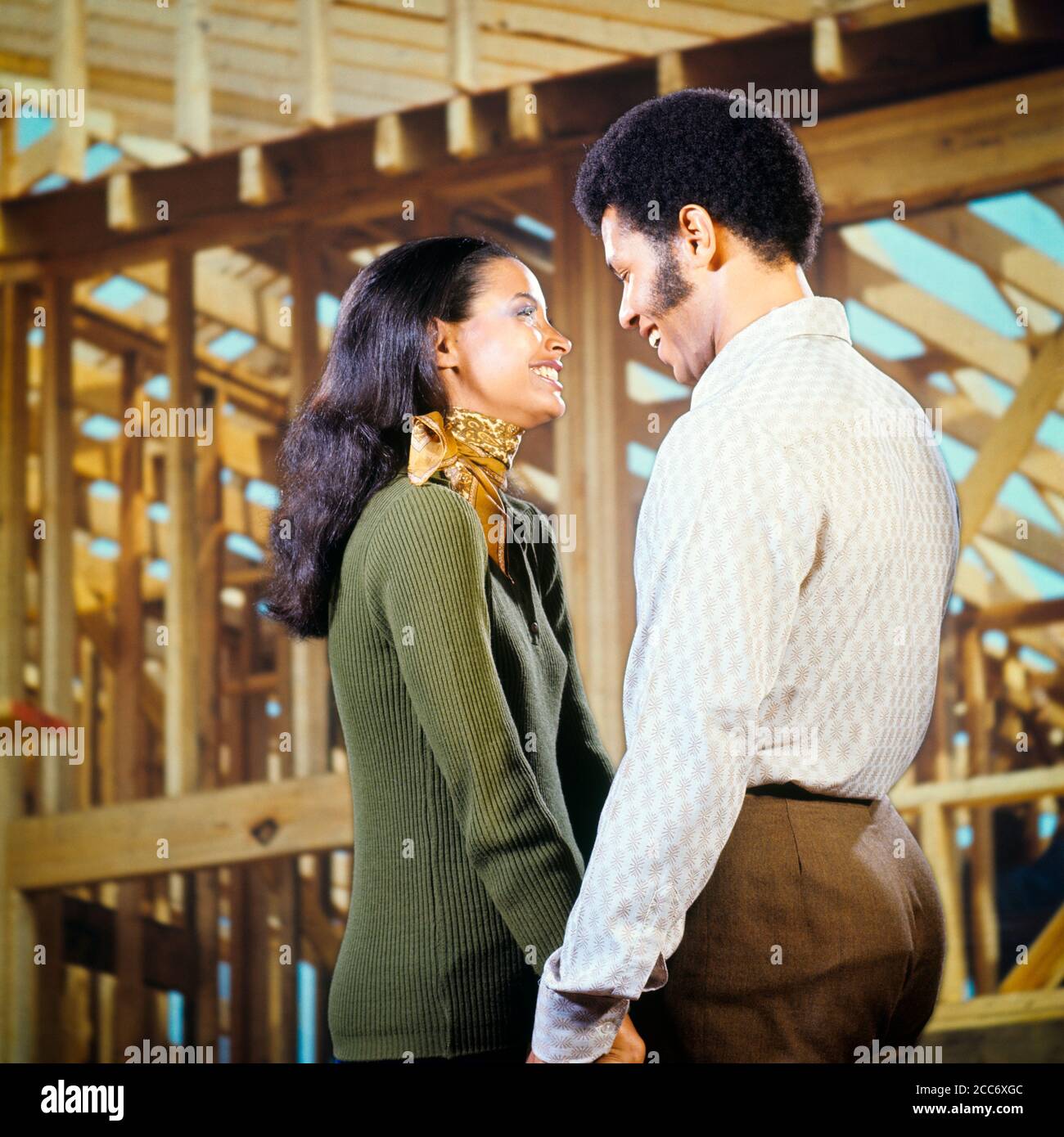 ANNI '70 SORRIDE UNA COPPIA AFRO-AMERICANA CHE TIENE LE MANI GUARDANDO L'UNA L'ALTRA AMOREVOLMENTE DI FRONTE ALLA NUOVA CASA IN COSTRUZIONE - KS8372 HAR001 HARS VECCHIA MODA 1 STILE COMUNICAZIONE FORTE GIOIA FELICE LIFESTYLE SODDISFAZIONE FEMMINE CASE SPOSATE STUDIO SHOT CONIUGE MARITI HOME VITA COPIA SPAZIO AMICIZIA MEZZA LUNGHEZZA DONNE PERSONE RESIDENZIALE CURA MASCHI EDIFICI PARTNER SUCCESSO SOGNI FELICITÀ ALLEGRO AFRO-AMERICANI COMPOSITO AFRO-AMERICANO ECCITAZIONE ESTERNO BASSO ANGOLO NERO ETNIA ORGOGLIO OPPORTUNITÀ VISO CASE DEI CAPELLI SMILES CONNECTION CONCEPTUAL JOYFUL RESIDENCE ELEGANTE DI FRONTE Foto Stock