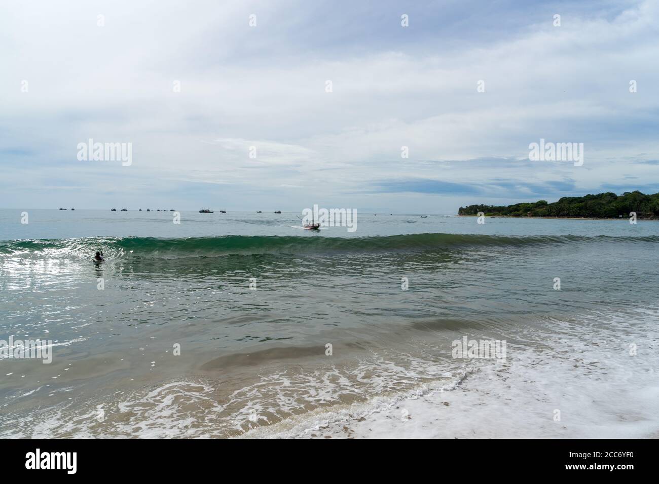 Spiaggia tropicale con palme. Tradizionale barca da pesca sul mare. Baia di Arugam, Sri Lanka Foto Stock