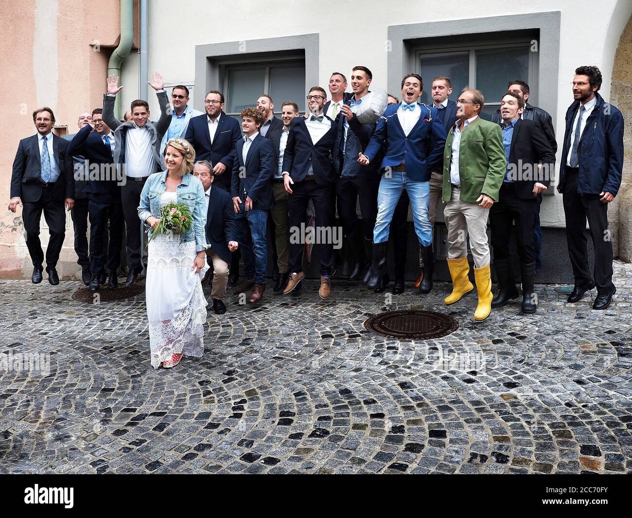 GUMPOLDSKIRCHEN, AUSTRIA - 09/01/2018. Bride e brommen saltano in stivali di gomma. Buon giorno di nozze piovoso. Foto Stock