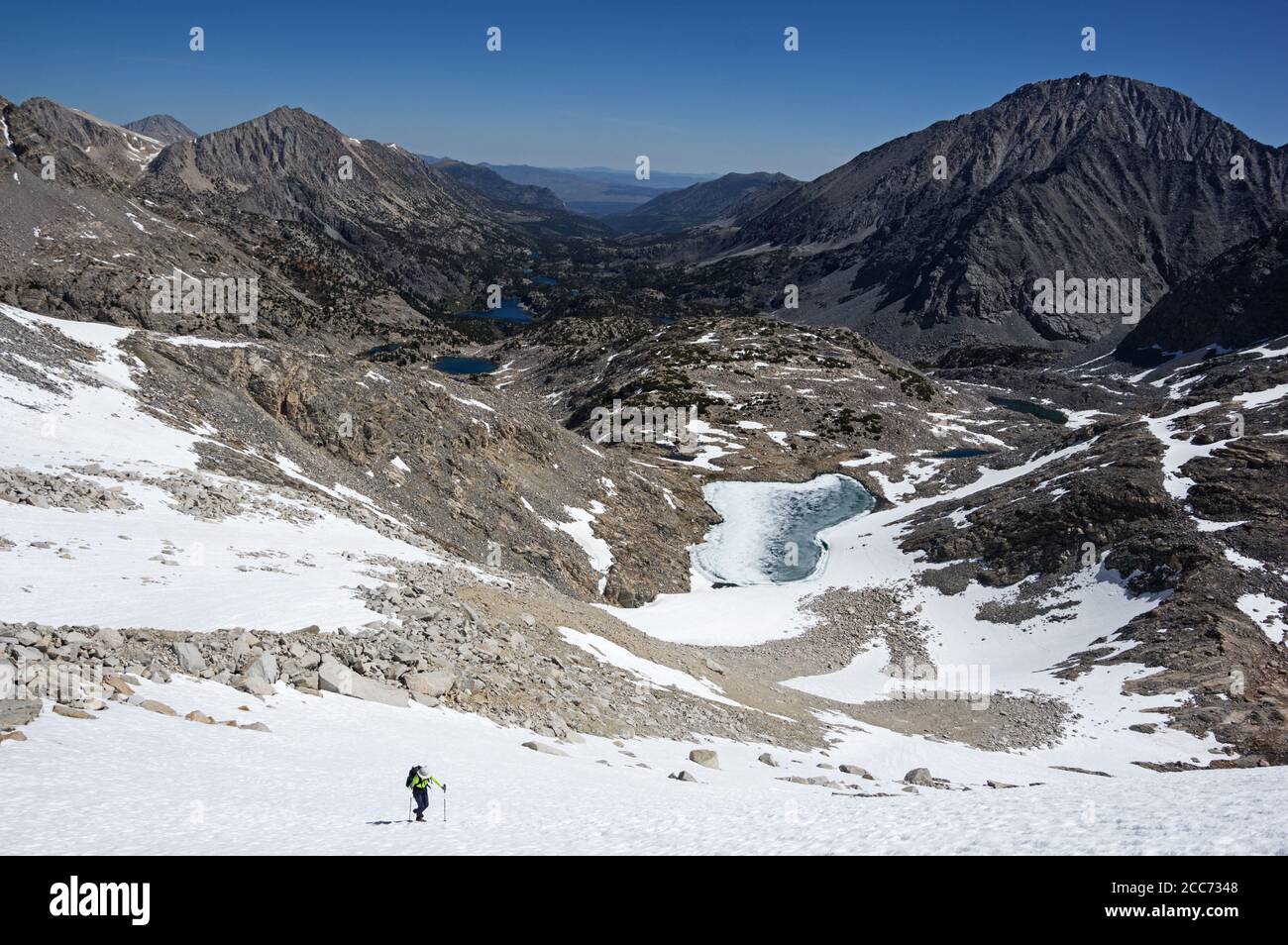 Donna lontana sale su campo di neve in Little Lakes Valley in La Sierra orientale Foto Stock
