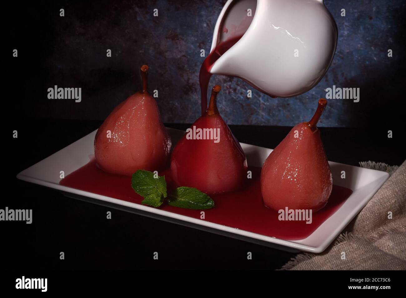 Pere in camicia in vino rosso con cannella e anice. Foto Stock