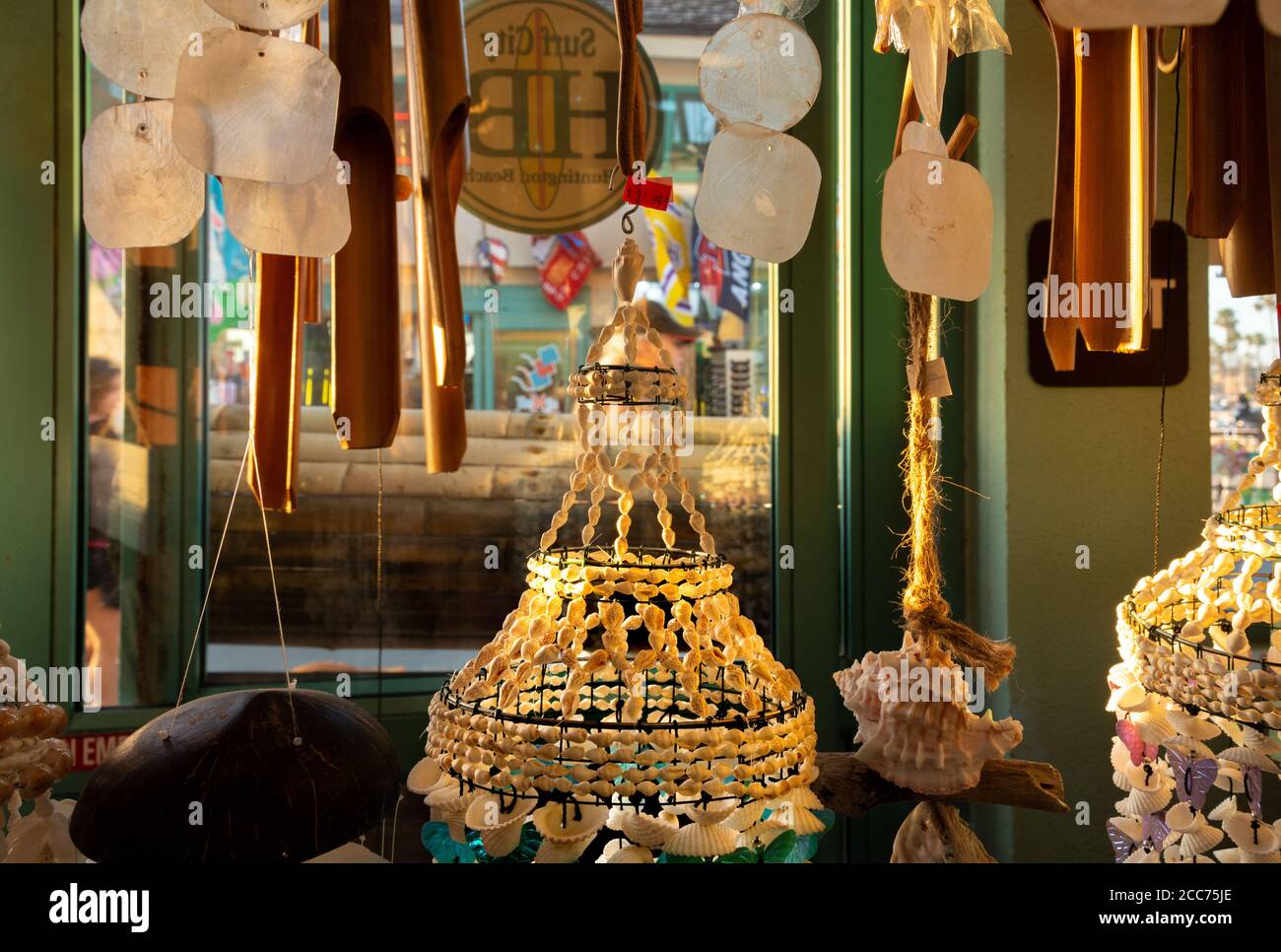 Interno della finestra del negozio sul molo di Huntington Beach che vende Chimes del vento di Seashell e decorazione domestica costiera. Foto Stock