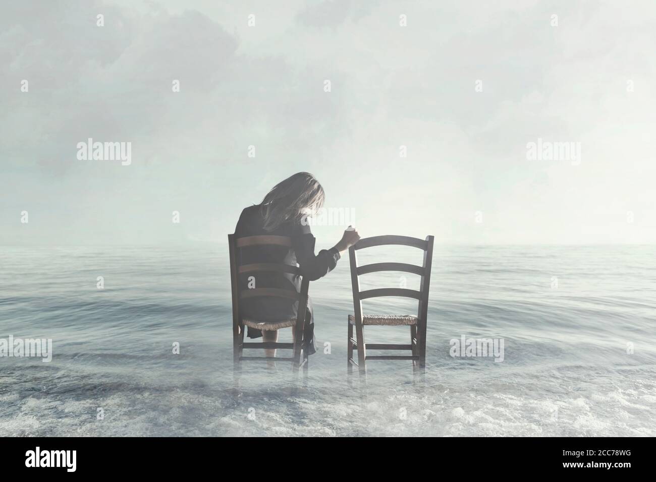 la donna triste guarda nostalgicamente alla sedia vuota del suo amante Foto Stock