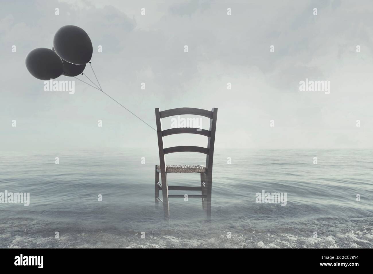 sedia solitairy con palloncini neri legati alla riva dell'oceano Foto Stock