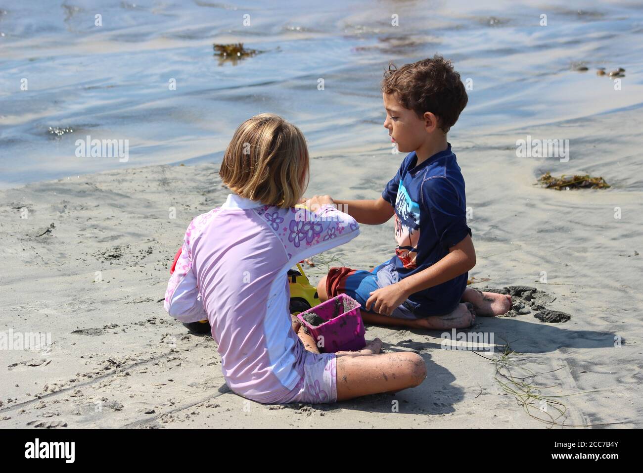 Due bambini (fratello e sorella) gioca insieme a giocattoli di sabbia in spiaggia Foto Stock