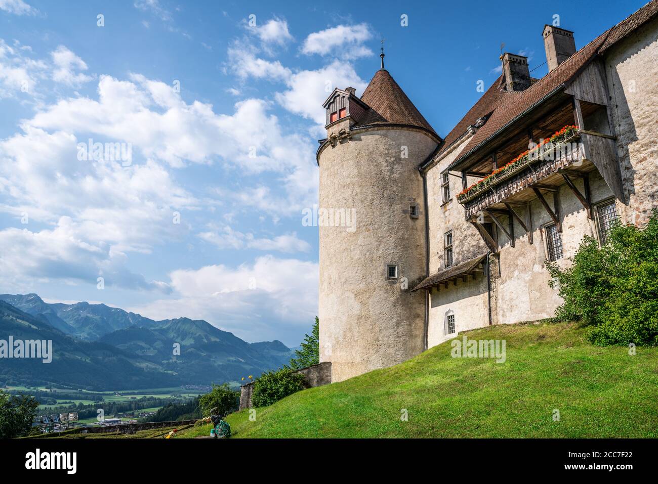 Gruyeres castello medievale dettagli vista con balcone torre e giardino E le montagne sullo sfondo a la Gruyere Friburgo Svizzera Foto Stock
