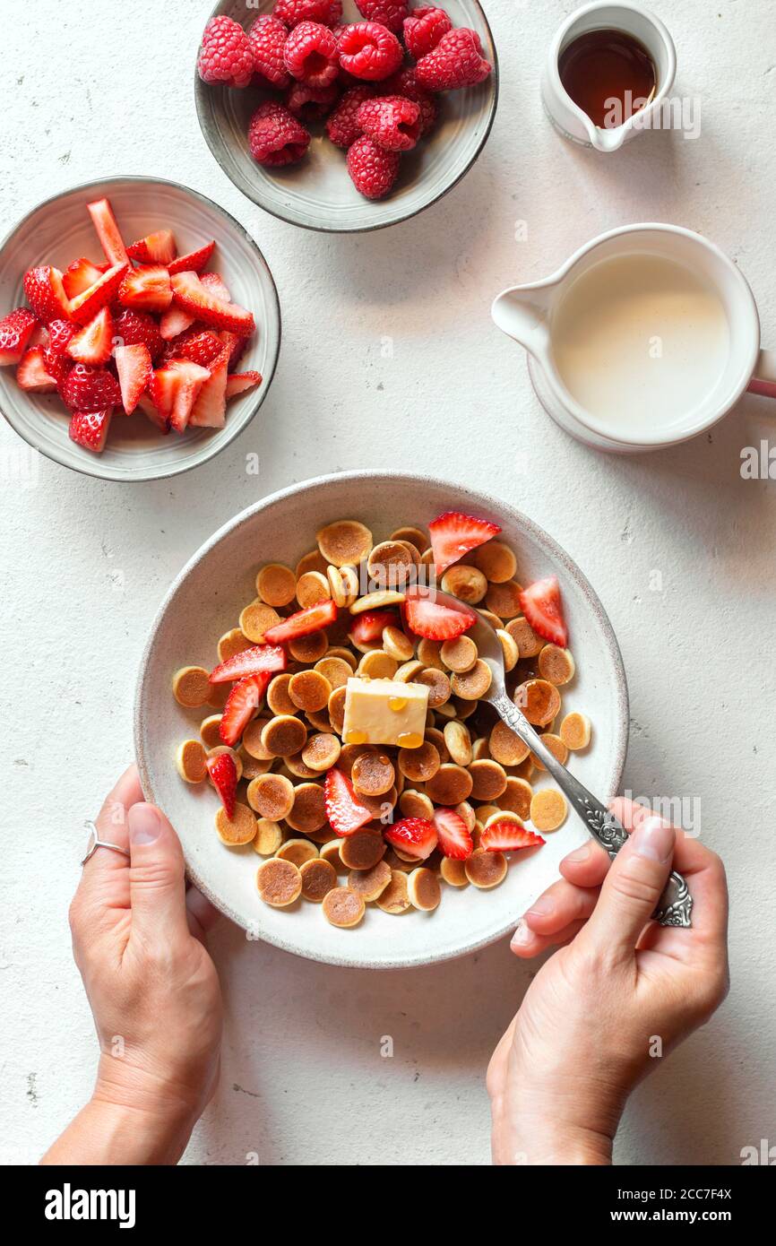 Frittelle di cereali con fragole in un recipiente bianco sfondo Foto Stock