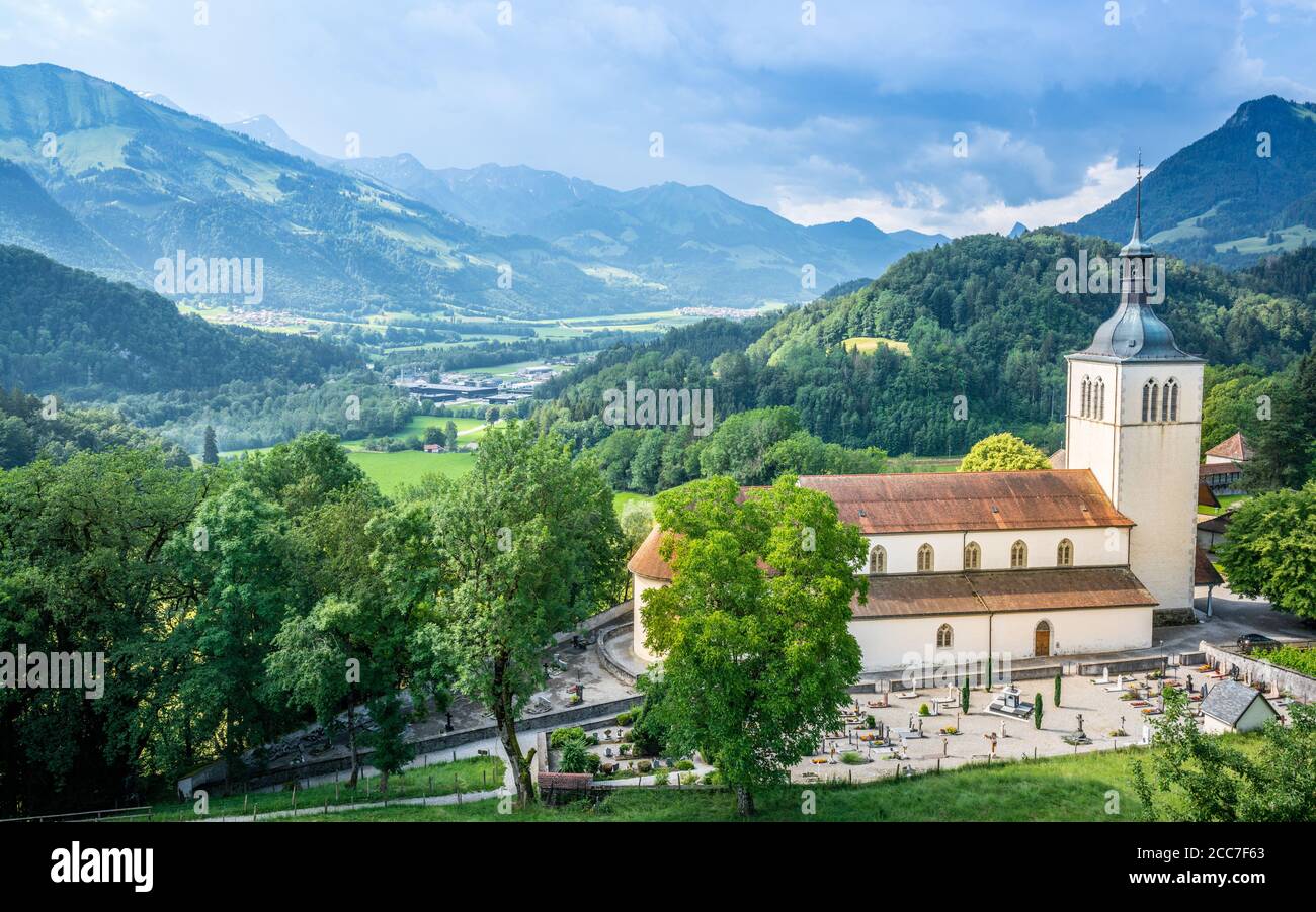Panorama della città di Gruyeres con la chiesa di San Teodulo e cimitero Vista e montagne sullo sfondo a la Gruyere Friburgo Svizzera Foto Stock