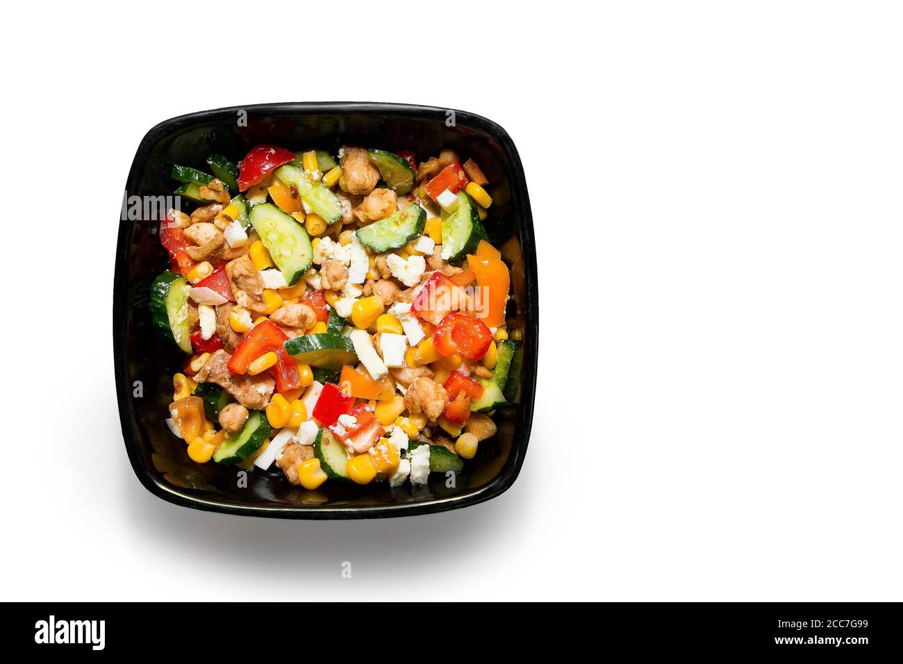 Gustosa insalata di verdure con pollo in un piatto nero isolato su sfondo bianco. Posiziona per il testo, vista dall'alto Foto Stock