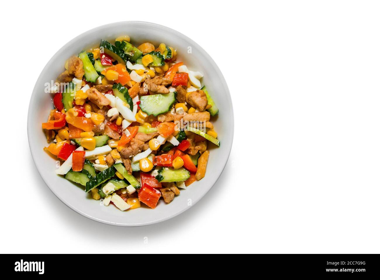 Insalata di verdure luminose in un piatto bianco isolato su fondo bianco. Cucinare una deliziosa insalata dietetica. Posiziona per il testo Foto Stock