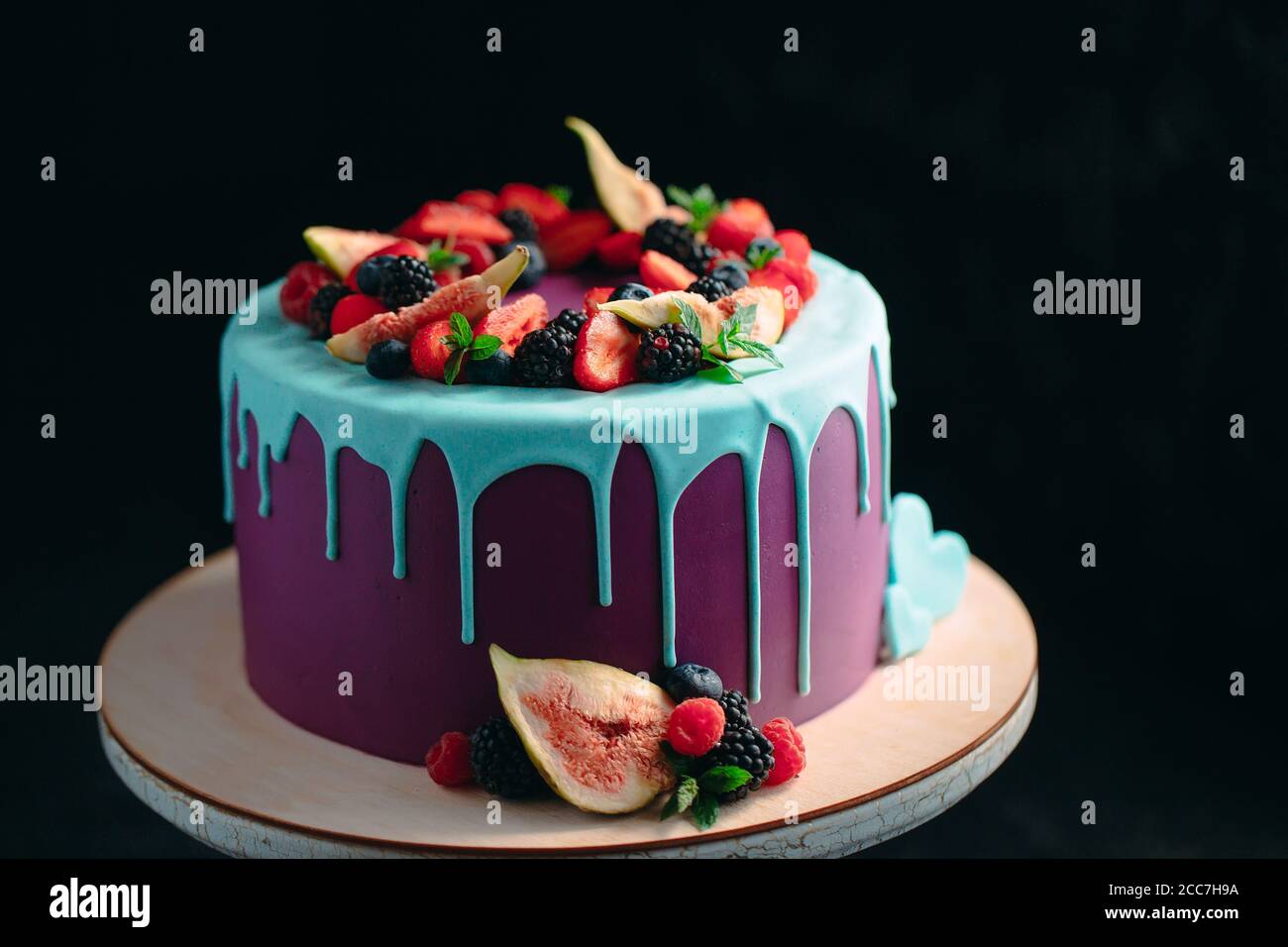 Torta di frutta decorata con figure, mirtilli e lamponi e menta. Foto Stock
