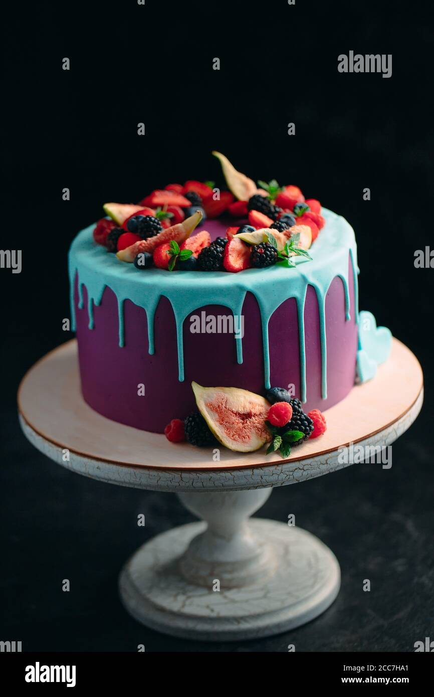Torta di frutta decorata con figure, mirtilli e lamponi e menta. Foto Stock