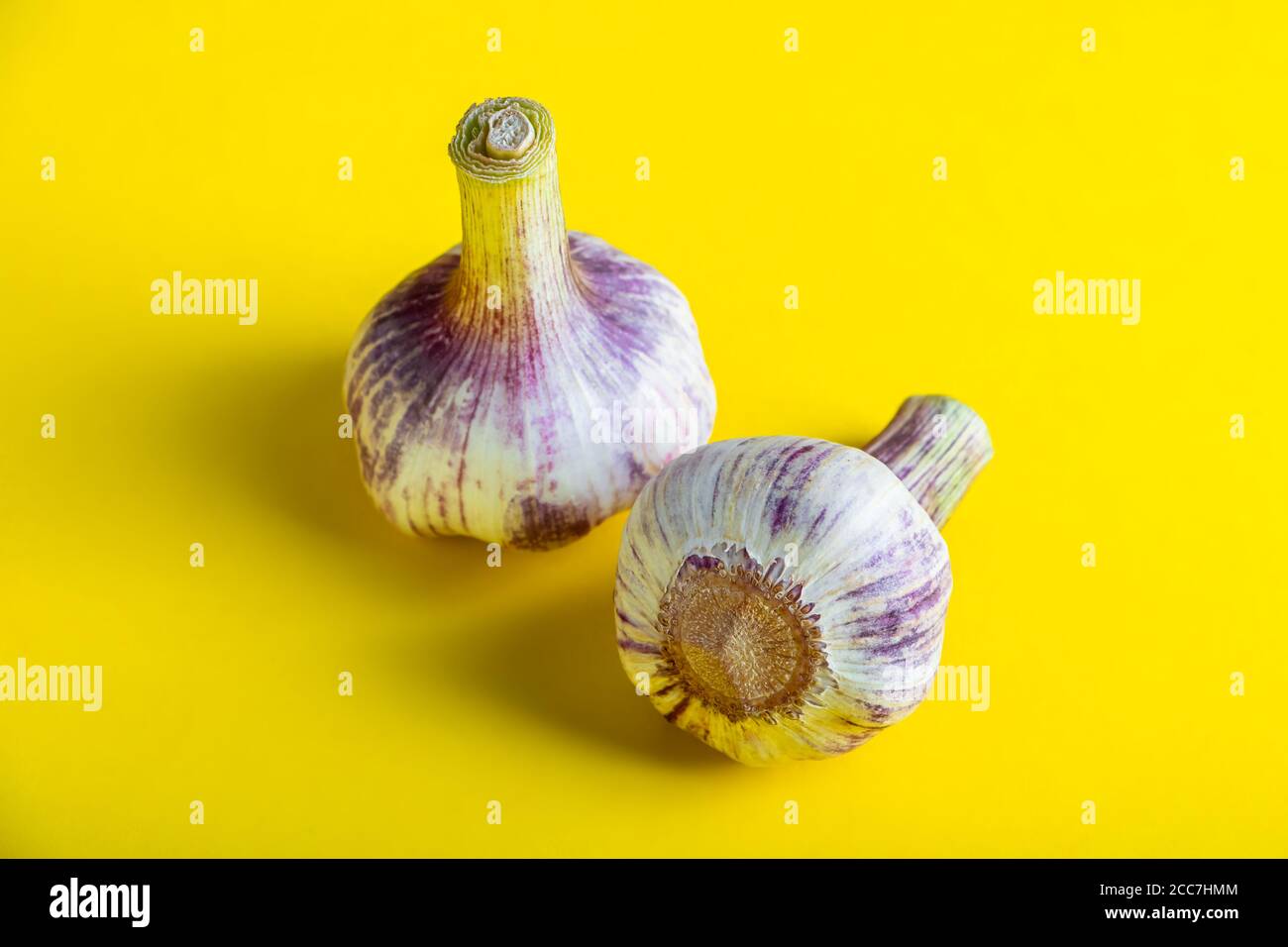 Aglio aromatico fresco su sfondo giallo primo piano. Foto Stock