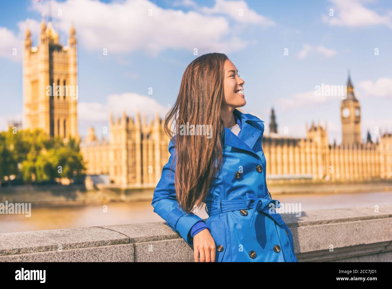 Londra città stile di vita Asian businesswoman Europa viaggio autunno in trench cappotto blu. Modello multirazziale in posa in outerwear autunnale alla moda a Westminster Foto Stock