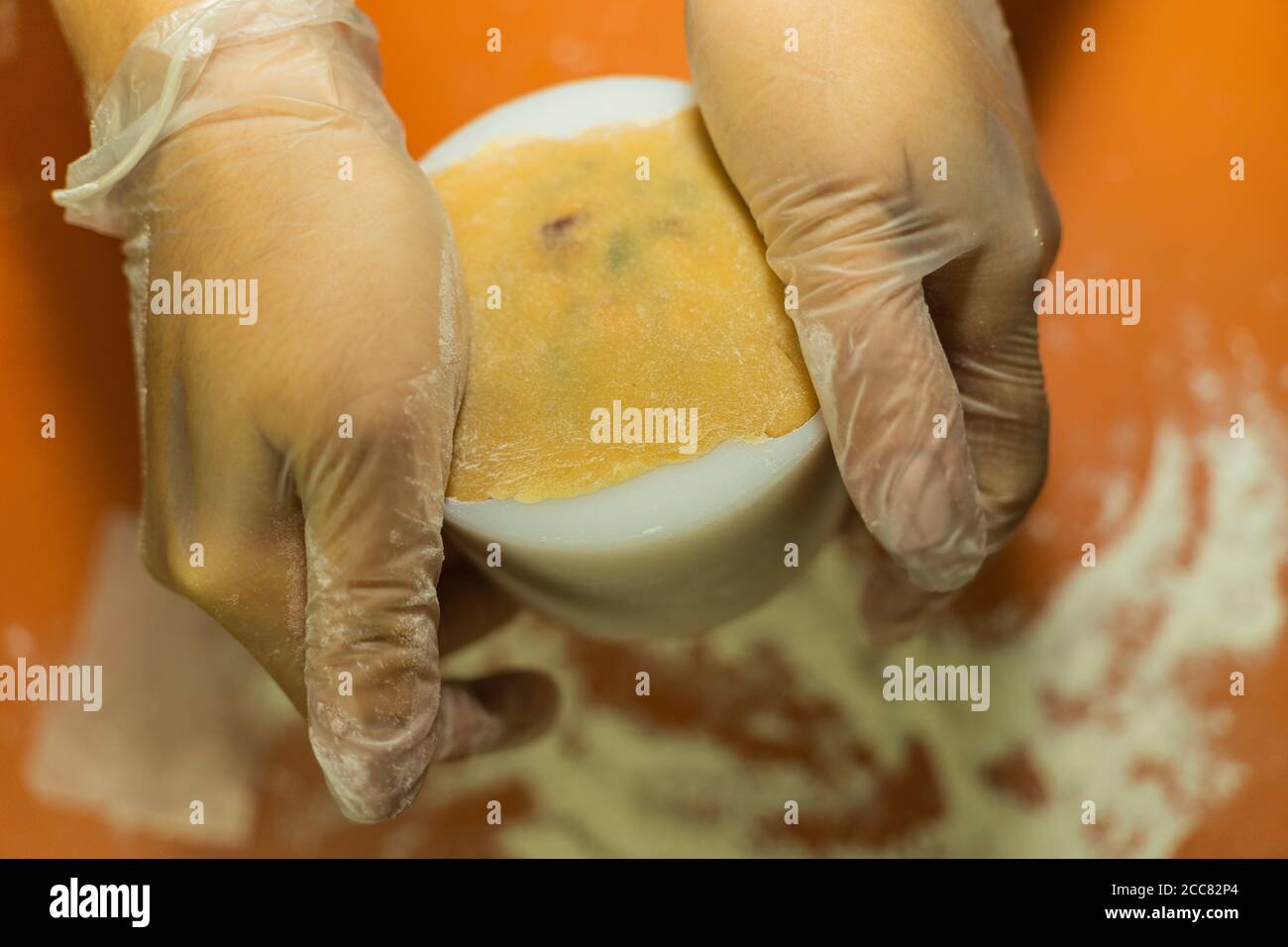 Le mani femminili fanno l'impasto per la mooncake, pasticceria cantonese fatta in casa per la torta sulla griglia da forno prima di cuocere per il festival tradizionale. Viaggi, vacanze, fo Foto Stock