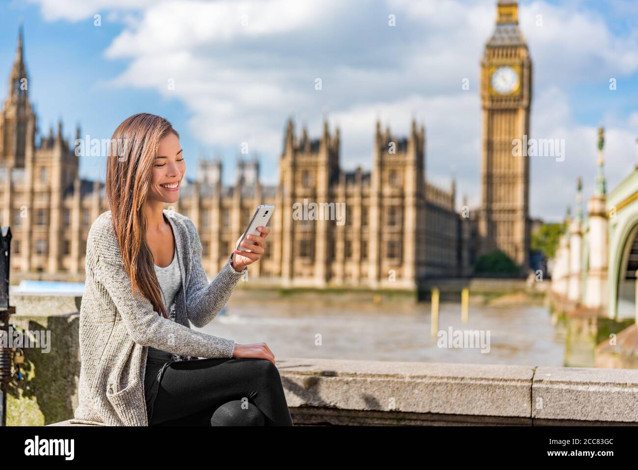Londra Urban People City lifestyle giovane donna asiatica utilizzando l'app per telefono cellulare SMS sui social media. Felice università studentessa tenente Foto Stock
